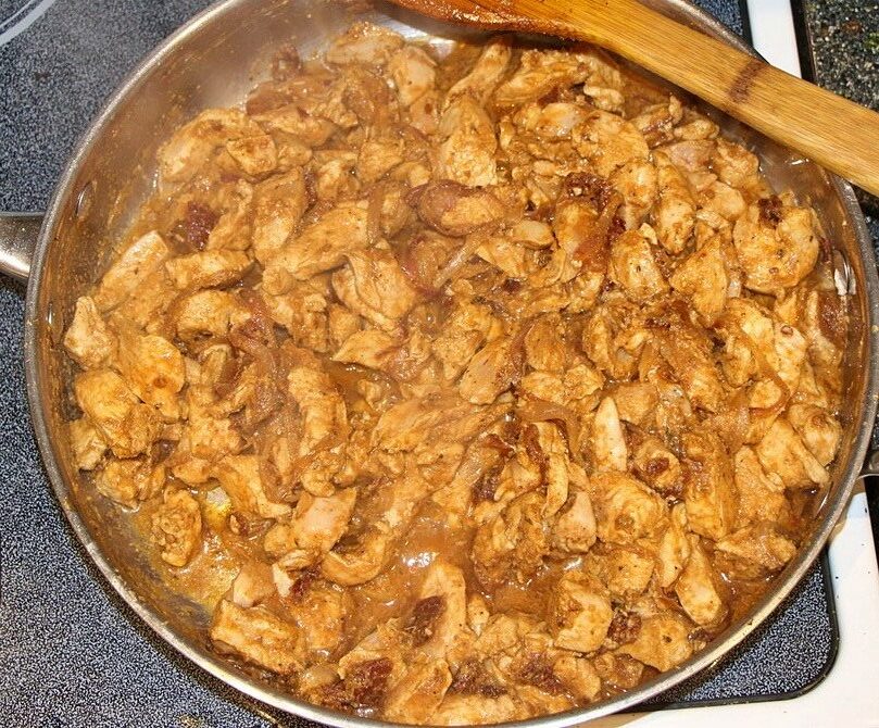 Chicken, spices and water in a pan for pulled chicken