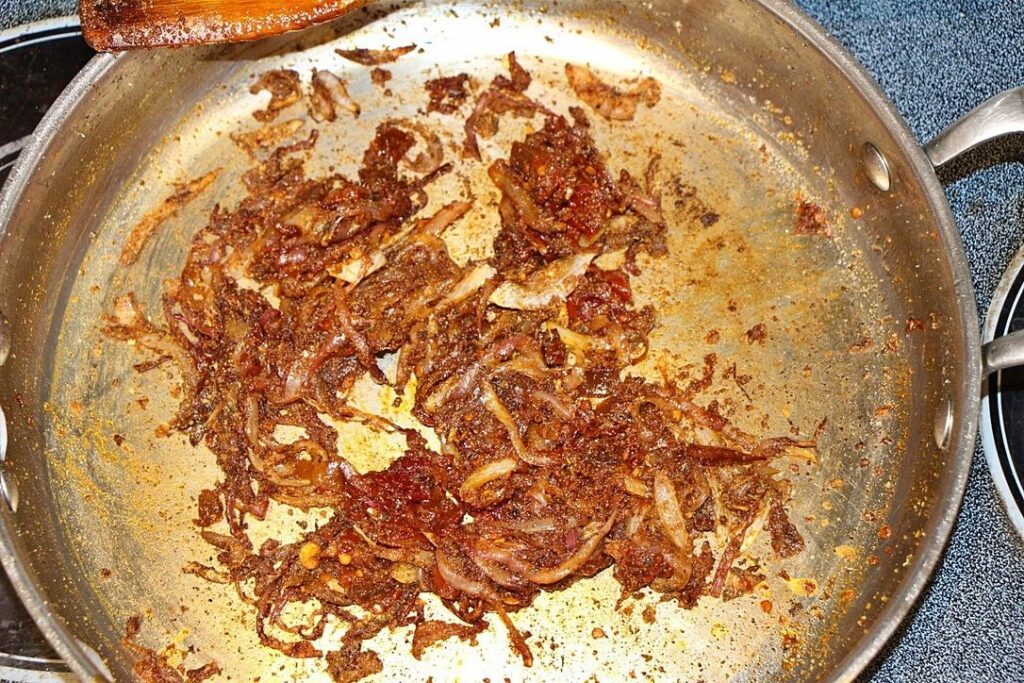 Onions and spices in a pan for pulled chicken