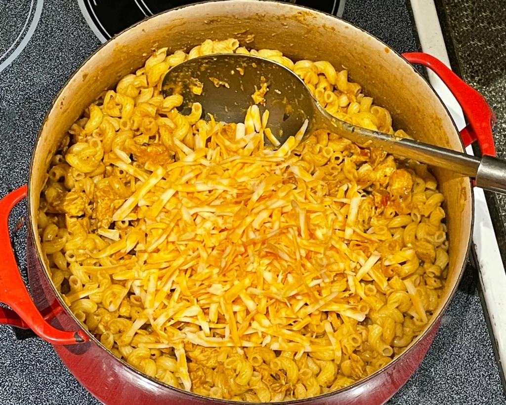 Butter chicken mac and cheese in pan with cheese