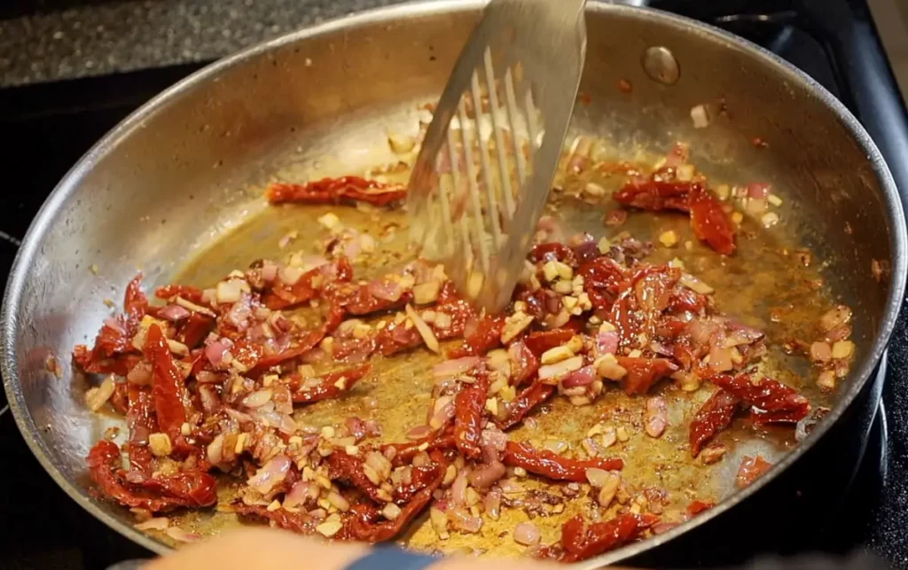 Onions and tomatoes in pan for Tuscan chicken