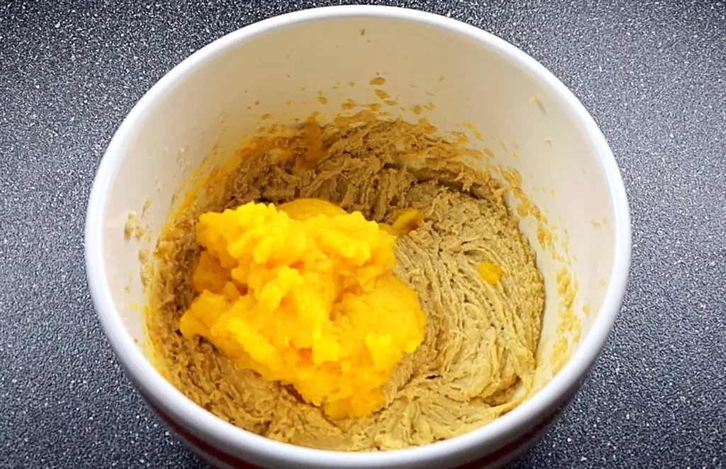 Adding pumpkin puree to pumpkin muffins batter